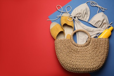 Photo of Stylish bag with beach accessories on color background, flat lay. Space for text