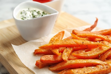 Photo of Sweet potato fries on wooden board, closeup