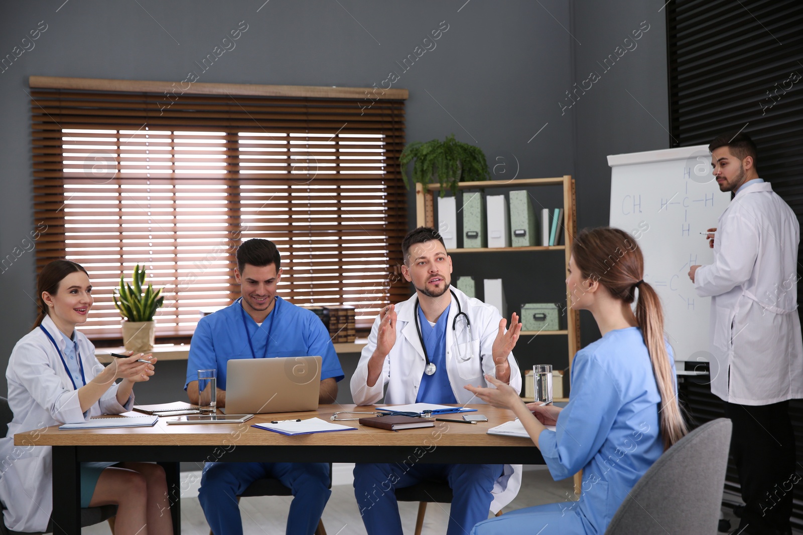 Photo of Team of professional doctors having meeting in office