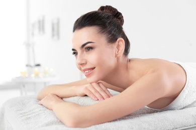 Young woman lying on massage table in spa salon