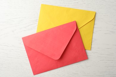 Photo of Paper envelopes on white wooden background, flat lay