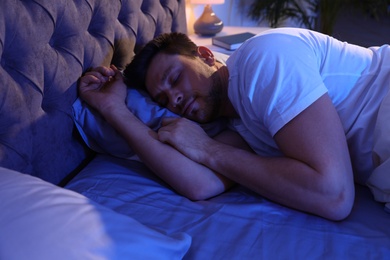 Photo of Handsome man sleeping on pillow at night. Bedtime