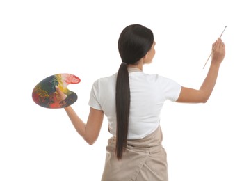 Photo of Young woman drawing with brush on white background, back view