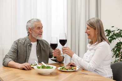Photo of Happy senior couple having romantic dinner at home