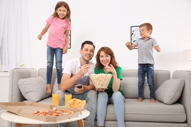 Photo of Family watching TV with popcorn in room