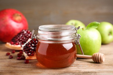 Photo of Honey, pomegranate and apples on wooden table. Rosh Hashana holiday