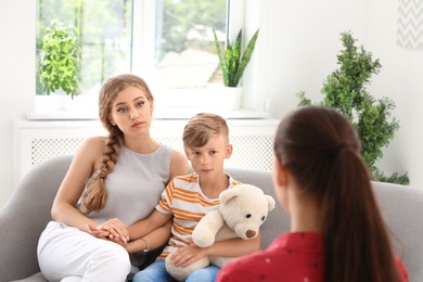 Photo of Young mother and her son visiting child psychologist in office