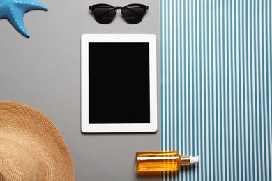 Photo of Flat lay composition with tablet and beach objects on color background