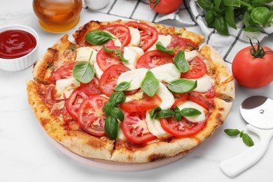 Photo of Delicious Caprese pizza with tomatoes, mozzarella and basil served on white marble table, closeup