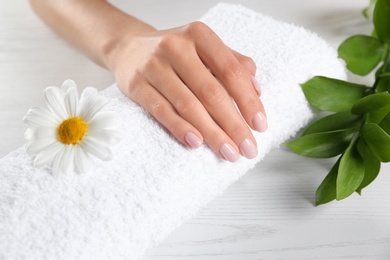 Photo of Beautiful female hand on towel, closeup. Spa treatment
