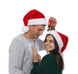 Happy couple standing under mistletoe bunch on white background