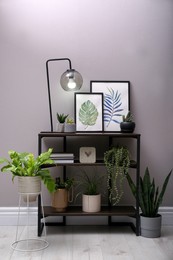 Photo of Stylish room interior with beautiful potted plants and console table