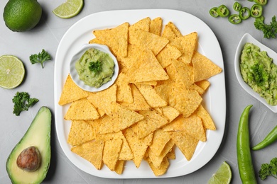 Photo of Flat lay composition with tasty Mexican nachos chips on grey table