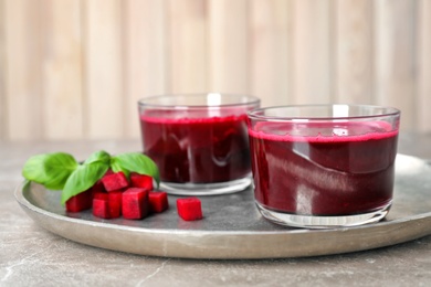 Photo of Glasses of fresh beet juice on metal tray