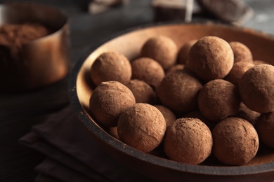 Photo of Plate with chocolate truffles on table, space for text