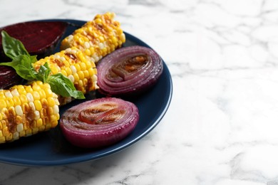 Photo of Delicious grilled vegetables on white marble table, space for text