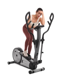 Photo of Tired woman after training on modern elliptical machine against white background