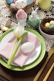 Photo of Festive table setting with painted eggs. Easter celebration