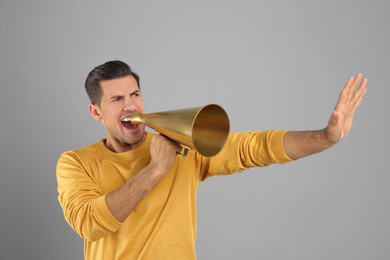 Photo of Handsome man with megaphone on grey background