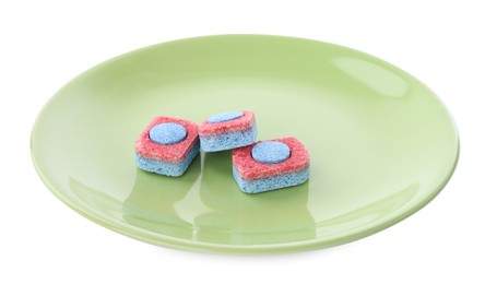 Photo of Green plate with dishwasher detergent tablets on white background