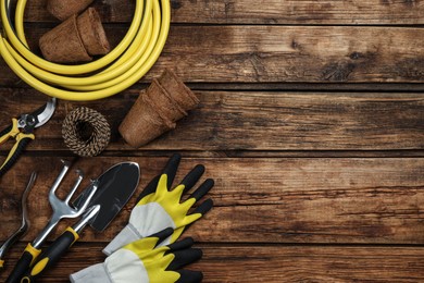 Photo of Flat lay composition with gardening tools on wooden background, space for text