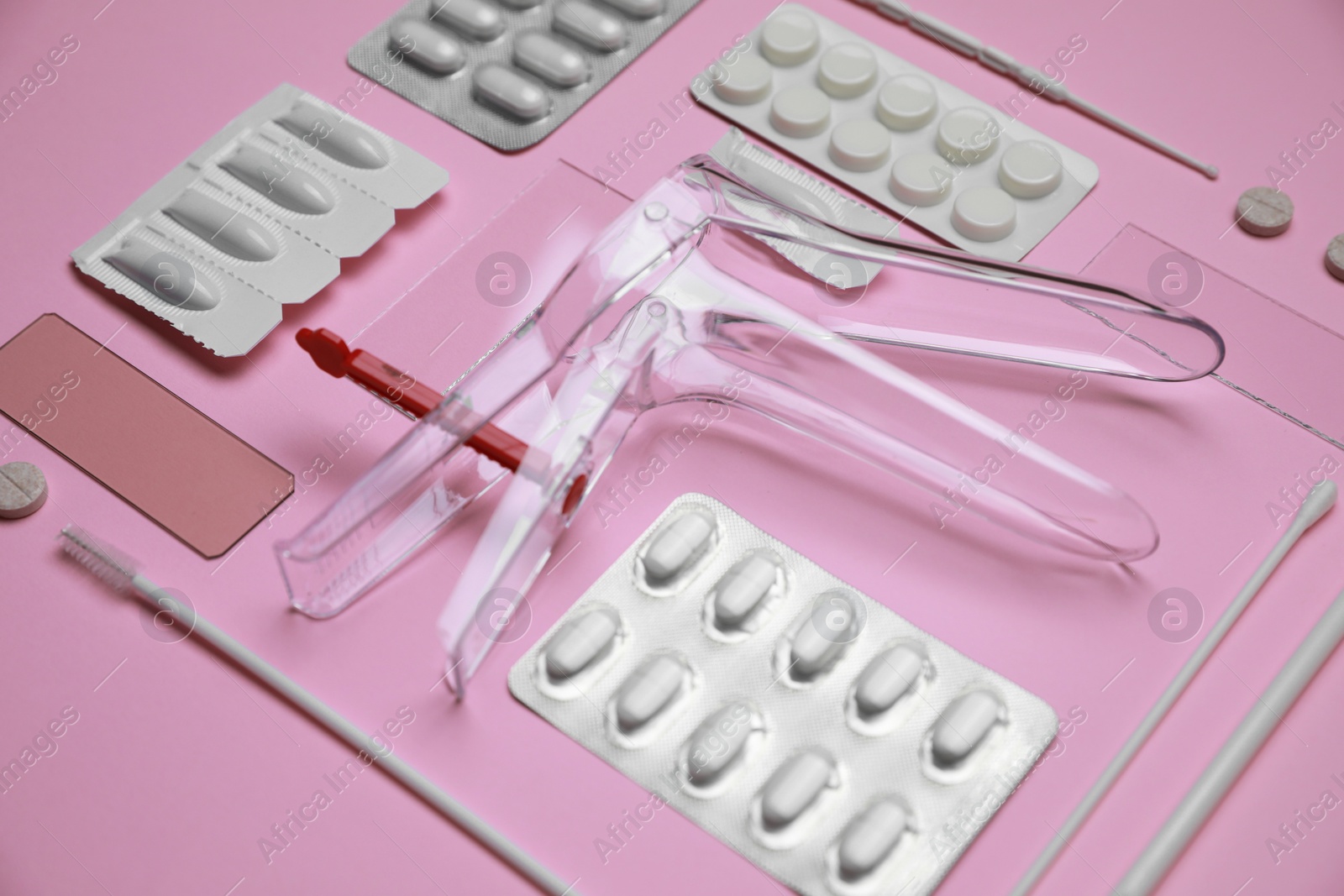 Photo of Sterile gynecological examination kit and medicaments on pink background