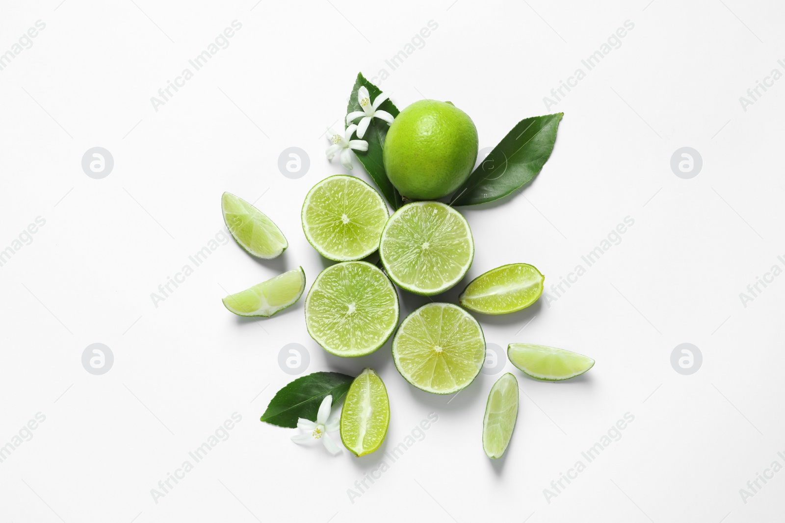 Photo of Limes, flowers and leaves on white background, top view. Citrus fruits