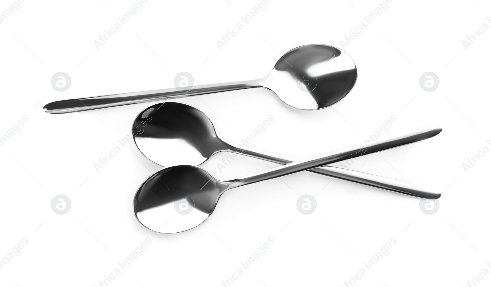 Photo of Clean shiny metal spoons on white background, top view