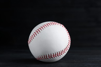 Baseball ball on black wooden table, closeup. Sports game