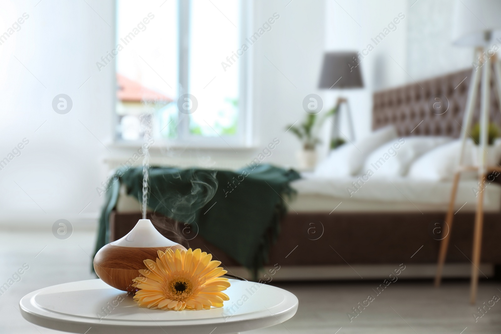 Photo of Aroma oil diffuser on table at home. Air freshener