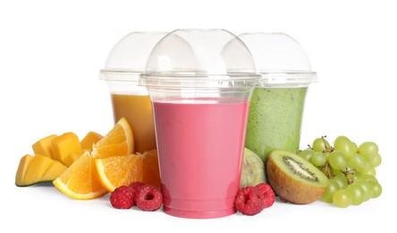 Photo of Plastic cups with delicious smoothies and ingredients on white background