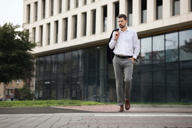 Photo of Handsome bearded businessman walking on city street