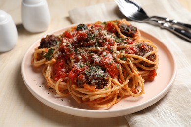 Photo of Delicious pasta with meatballs and tomato sauce served on wooden table