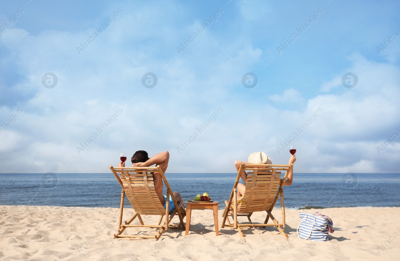 Photo of Couple with wine on sunny beach at resort