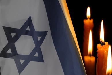 Image of Holocaust memory Day. Flag of Israel and burning candles