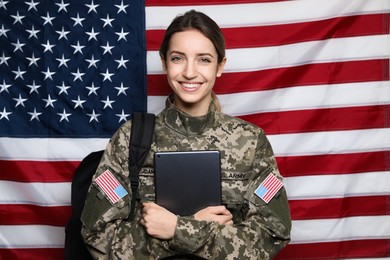Female cadet with backpack and tablet against American flag. Military education