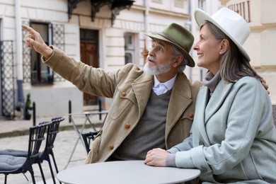 Portrait of affectionate senior couple sitting in outdoor cafe