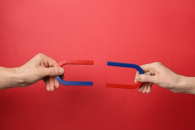 People holding magnets on color background, closeup