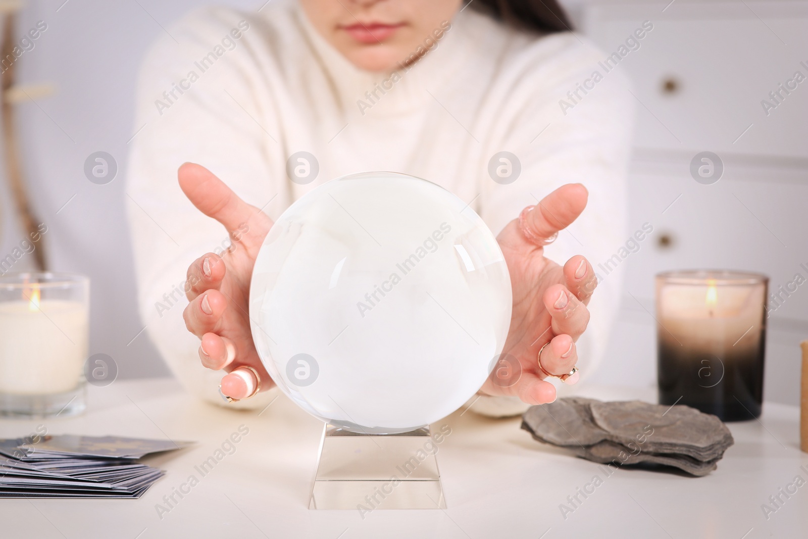 Photo of Soothsayer using crystal ball to predict future at table indoors, closeup