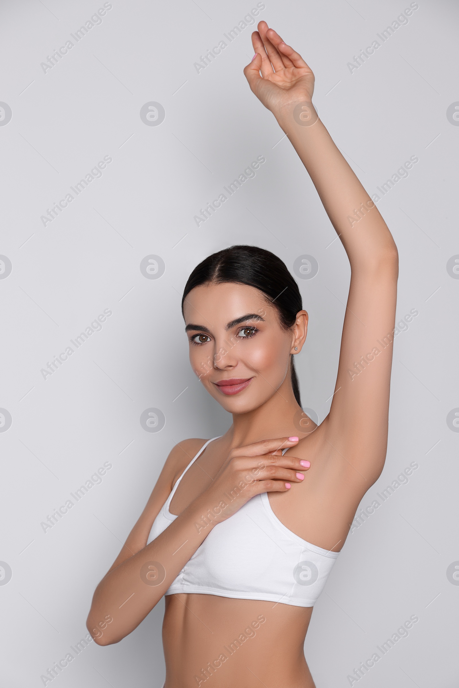 Photo of Young woman showing smooth skin after epilation on white background