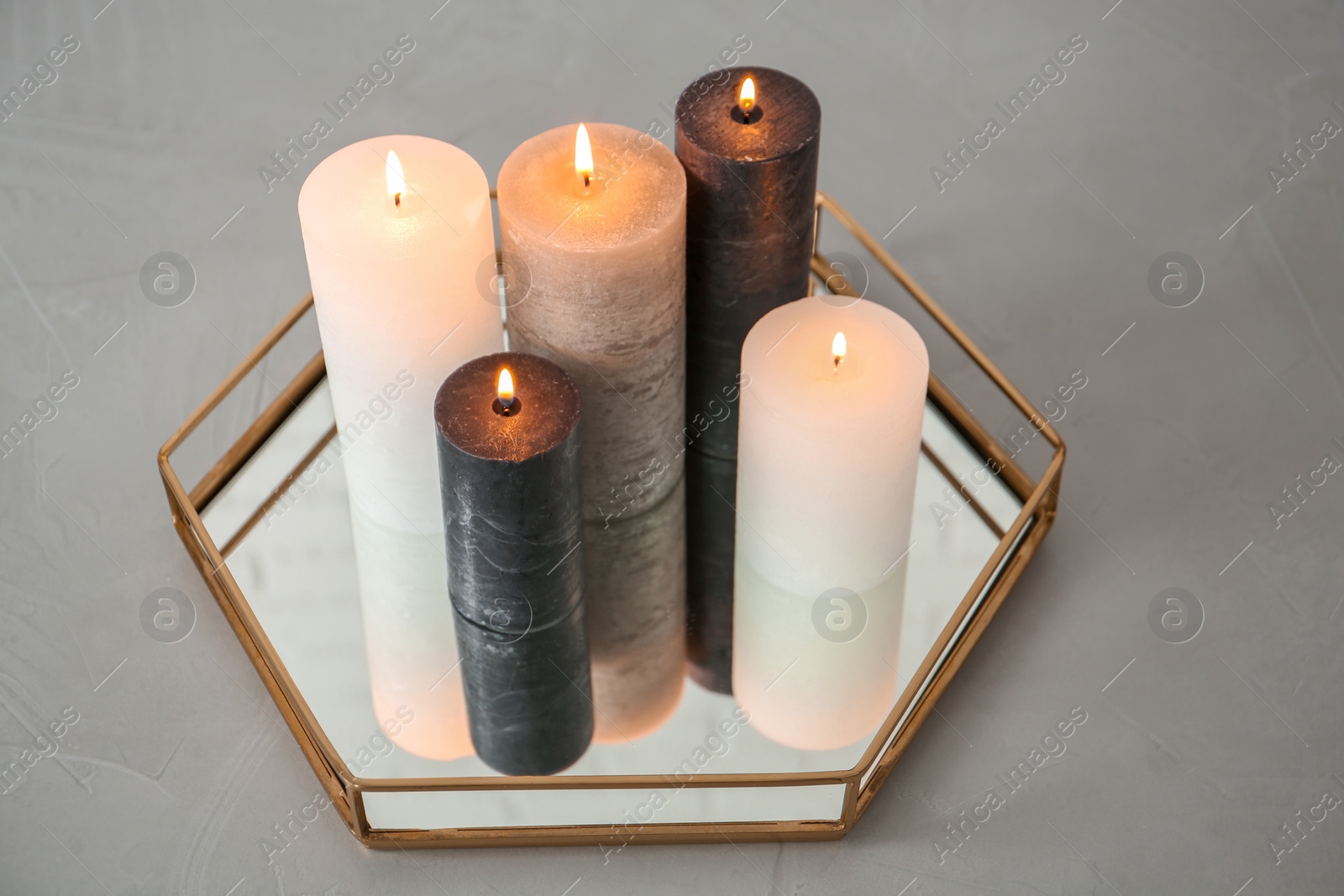 Photo of Tray with decorative wax candles on gray table