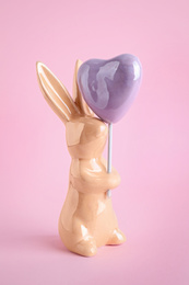 Photo of Bunny ceramic figure as Easter decor on pink background