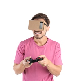 Young man using cardboard virtual reality headset, isolated on white