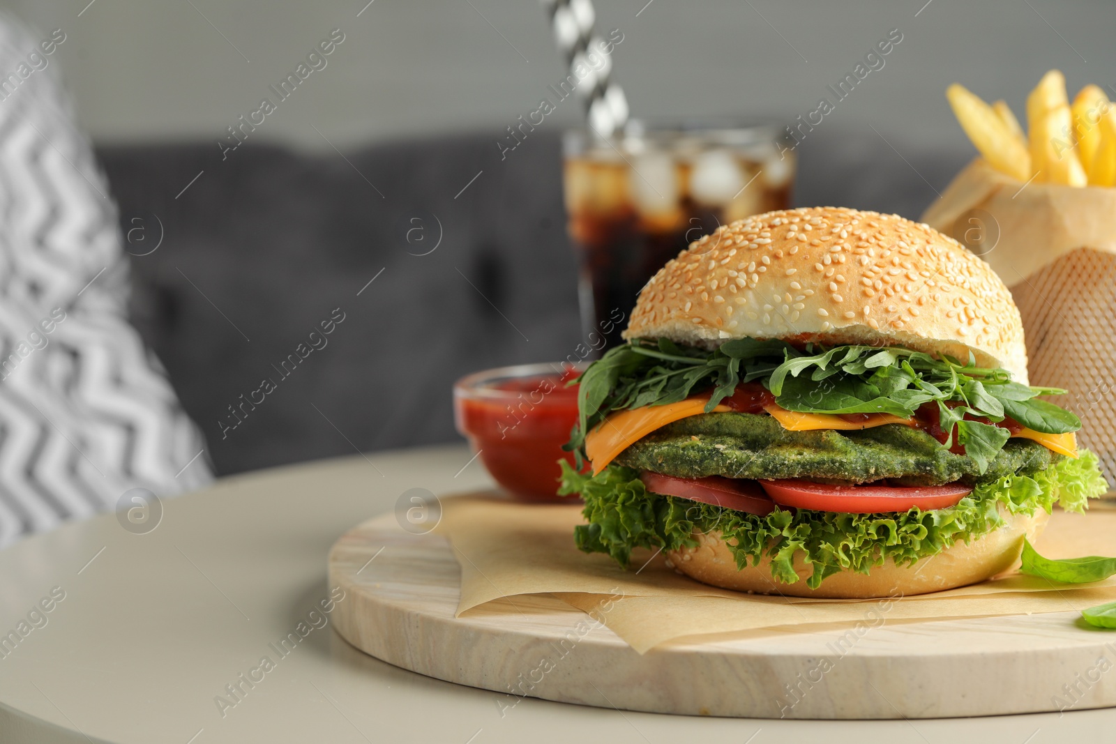 Photo of Tasty vegetarian burger served with french fries and soda drink on white table, closeup. Space for text