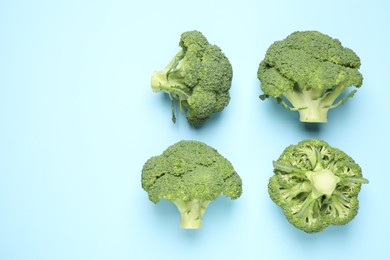 Fresh tasty broccoli on light blue background, flat lay