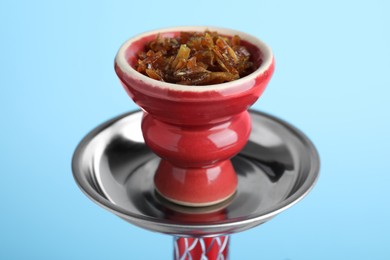 Photo of Modern hookah with tobacco on light blue background, closeup