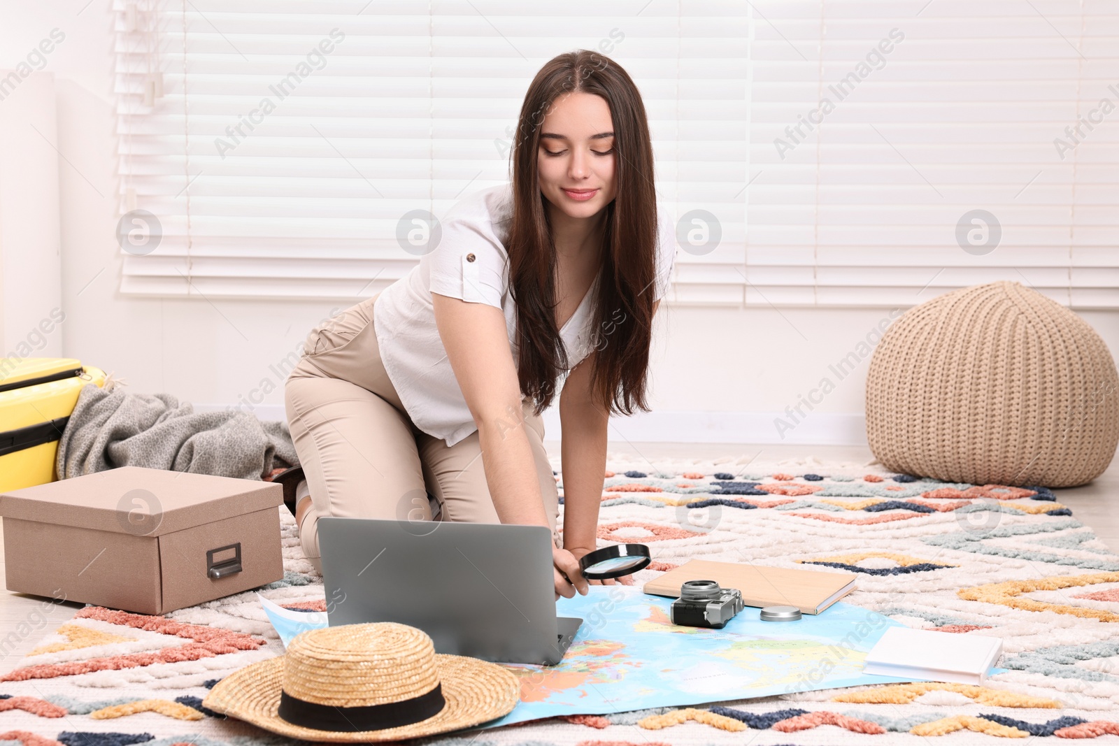 Photo of Travel blogger with magnifying glass and map planning trip at home