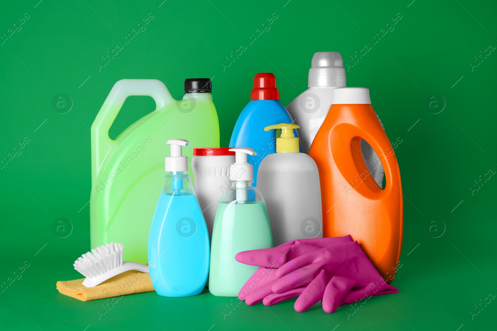 Photo of Different cleaning supplies and tools on green background