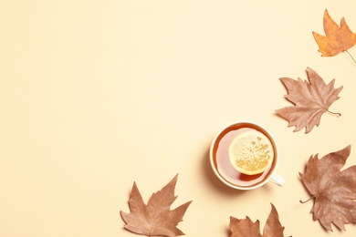 Flat lay composition with hot cozy drink and autumn leaves on color background. Space for text