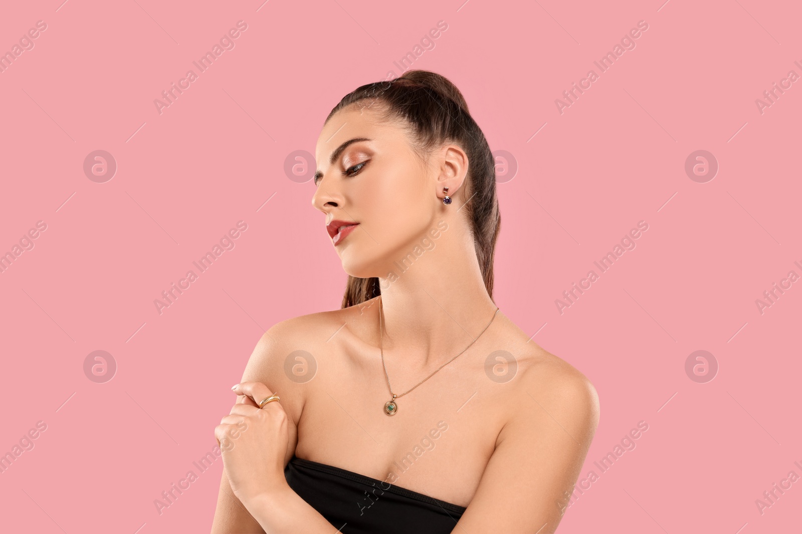 Photo of Beautiful woman with elegant jewelry on pink background